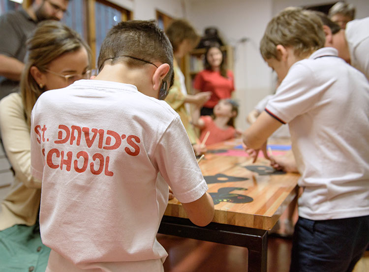 niños en clase levantando las manos para responder preguntas